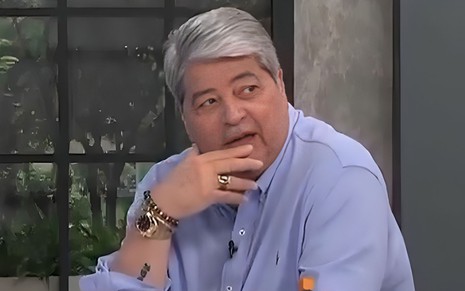 Datena está boquiaberto, com a mão no queixo e olhando para o lado