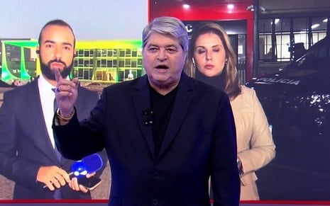 José Luiz Datena tem expressão séria na frente do telão do Brasil do Povo