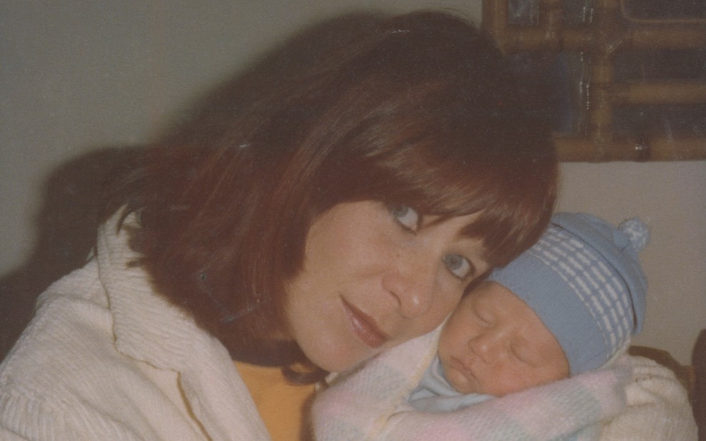 Rita Lee segurando seu filho, ainda bebê, Beto em foto dos arquivos pessoais da família