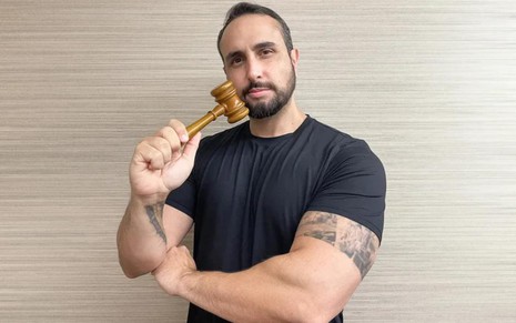 O influenciador Rodrigo Góes segurando martelo de juiz, posando para foto publicada no Instagram