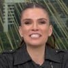 Sabina Simonato sorridente no Bom Dia Brasil, usando uma jaqueta preta com detalhes em prata