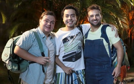 Konstantino Atan, Gustavo Daneluz e Nicholas Torres posam abraçados para foto no cenário de A Caverna Encantada