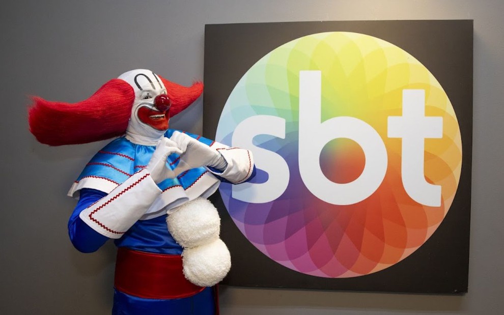 O palhaço Bozo em frente ao logo do SBT