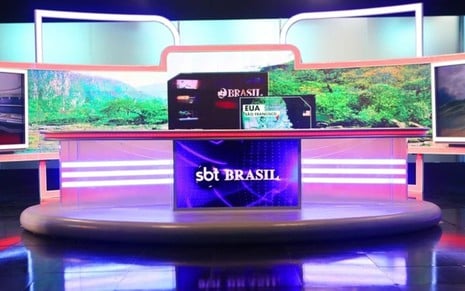 Estúdio do SBT Brasil, com bancada, telão e imagens ao fundo