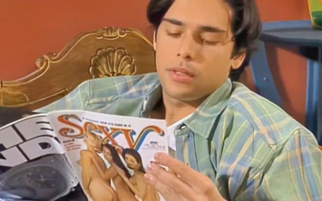 Jiddu Pinheiro tem expressão de tesão enquanto segura revista Sexy em cena de Chiquititas