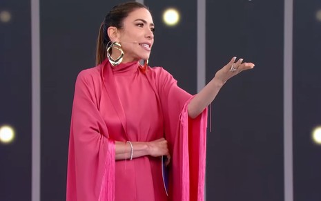 Patricia Abravanel tem expressão contrariada no palco; ela usa um vestido rosa