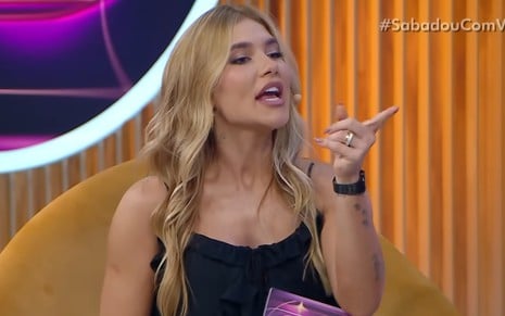 Virginia aponta o dedo em riste para o lado, com expressão de confronto, no cenário do Sabadou