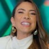 Patricia Abravanel sorridente no cenário do Show do Milhão