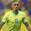 Raphinha, da Seleção Brasileira, comemora gol e veste uniforme amarelo com detalhes verdes