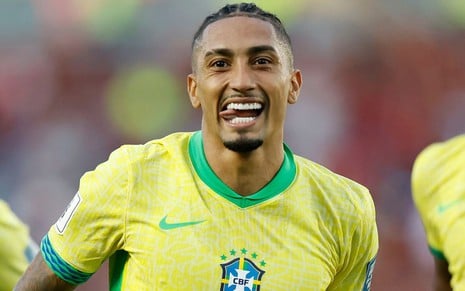 Raphinha, da Seleção Brasileira, comemora gol e veste uniforme amarelo com detalhes verdes