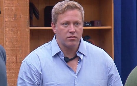 Foto mostra Sergio Hondjakoff em A Fazenda 18; ele veste camiseta azul