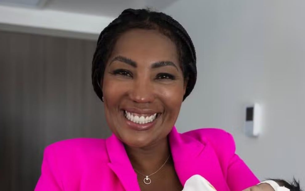 Silvana Oliveira, mãe de Ludmilla, sorrindo com a neta no colo