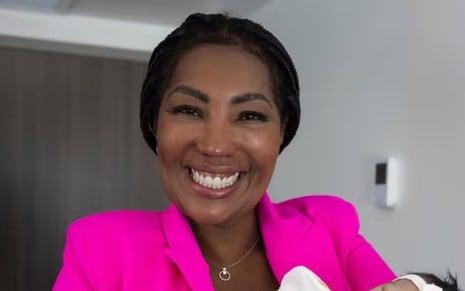 Silvana Oliveira, mãe de Ludmilla, sorrindo com a neta no colo