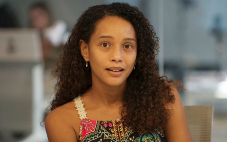 Taís Araujo sorri discretamente em cena como Raquel na novela Vale Tudo