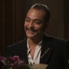 O ator Eduardo Sterblitch sorrindo, segurando buquê de flores, em frente à atriz Maria Eduarda de Carvalho em cena de Garota do Momento