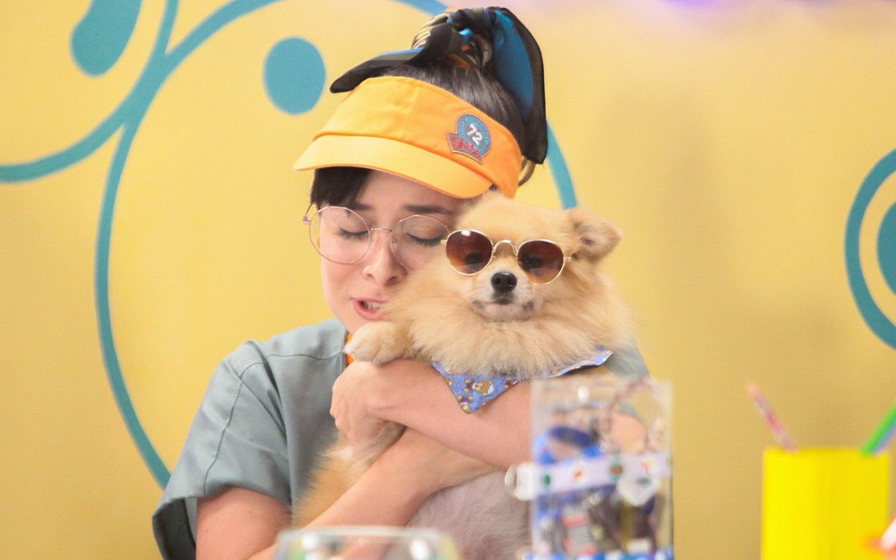 Betina (Thay Bergamim) segura um filhote de cachorro em cena da novela A Caverna Encantada