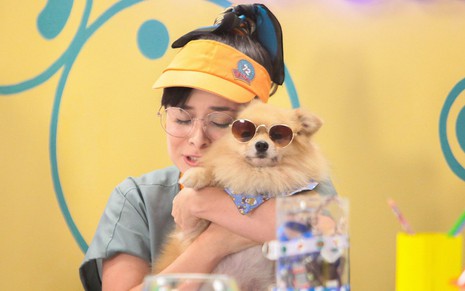 Betina (Thay Bergamim) segura um filhote de cachorro em cena da novela A Caverna Encantada