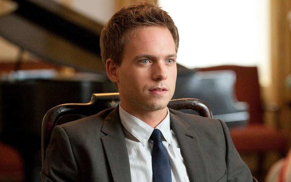 Patrick J. Adams tem expressão de choque e olhar distante em cena de Suits