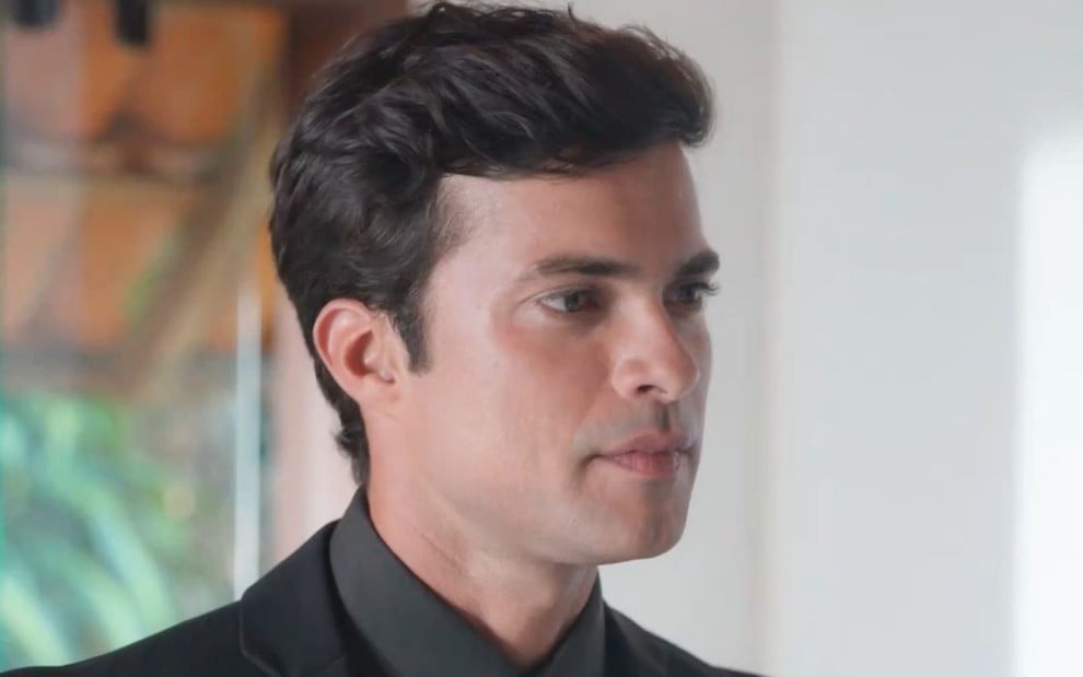 Victor Sparapane usa um terno preto e está com expressão séria em cena de A Vida Secreta do Meu Marido Bilionário