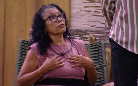 Vilma Nascimento coloca as mãos no colo e olha para cima; Diego Hypolito está de costas no canto da imagem