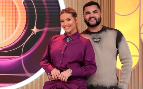 Virginia Fonseca e Lucas Guedes lado a lado, sorrindo, no estúdio do programa dela no SBT