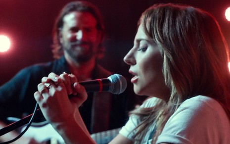 Lady Gaga canta enquanto é observada por Bradley Cooper em cena de Nasce Uma Estrela