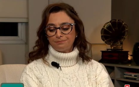 Catia Fonseca retorce a boca em live na sala de sua casa