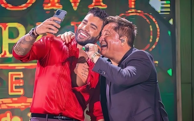 Gusttavo Lima e Leonardo posam sorridentes para selfie enquanto cantam em live