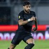 Yuri Alberto em campo pelo Corinthians, está chovendo, ele está com o uniforme totalmente preto