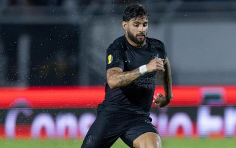 Yuri Alberto em campo pelo Corinthians, está chovendo, ele está com o uniforme totalmente preto