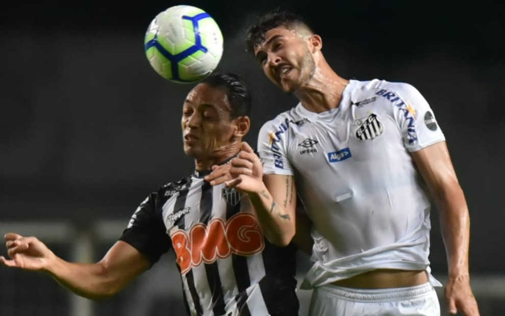 O atacante Ricardo Oliveira (à esq.) e o zagueiro Gustavo Henrique disputam bola no jogo de ida - DIVULGAÇÃO/SANTOS