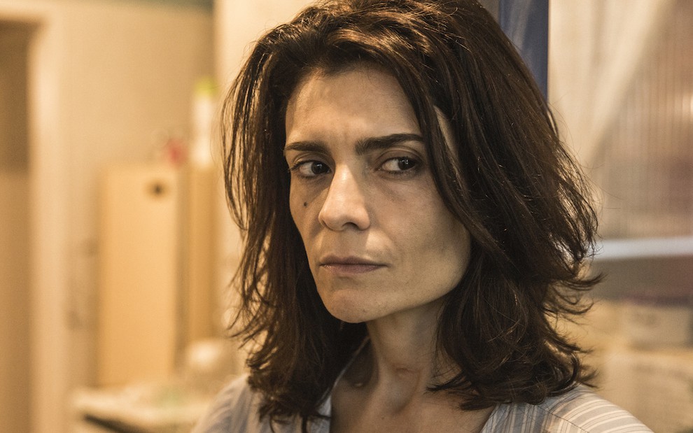 A atriz Arieta Corrêa apresenta uma expressão desconfiada em cena da novela Amor de Mãe, da TV Globo, em que atua como Leila