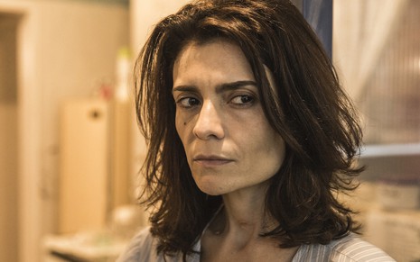 A atriz Arieta Corrêa apresenta uma expressão desconfiada em cena da novela Amor de Mãe, da TV Globo, em que atua como Leila