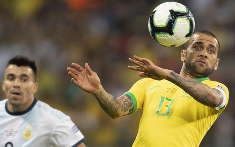 Eleito melhor jogador do Brasil contra a Argentina, Daniel Alves (à dir.) disputa bola com Acuña - LUCAS FIGUEIREDO/CBF