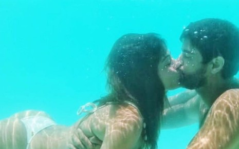Os atores Carol Castro e Bruno Cabrerizo se beijam embaixo d'água em uma piscina, em foto publicada no Instagram