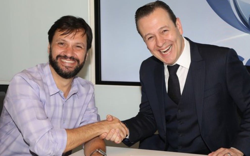 Antonio Guerreiro e Celzo Zucatelli apertam as mãos na assinatura de contrato do apresentador com a Record