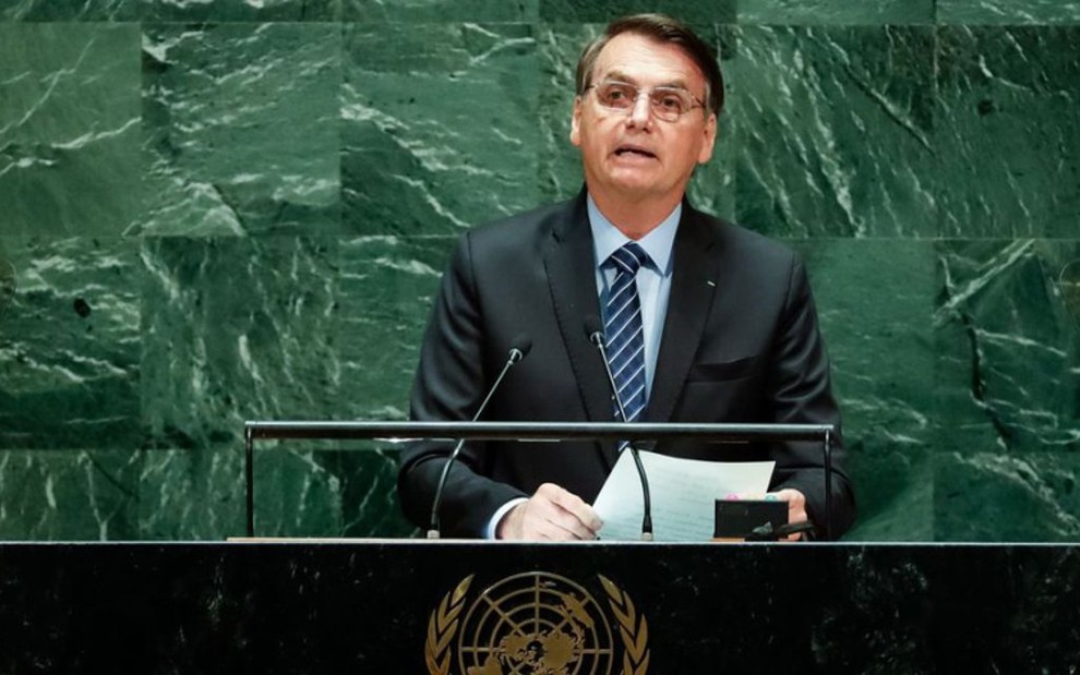 O presidente Jair Bolsonaro discursa em palanque na Assembleia da Organização das Nações Unidas, com símbolo da ONU ao fundo