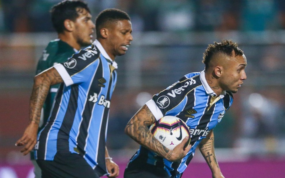 Everton Cebolinha, do lado direito, segura a bola após marcar gol do Grêmio; atrás dele, André e Gustavo Gómez