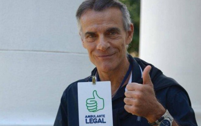 Ex-ator da Globo Mário Gomes segura seu crachá de Ambulante Legal da Prefeitura do Rio de Janeiro