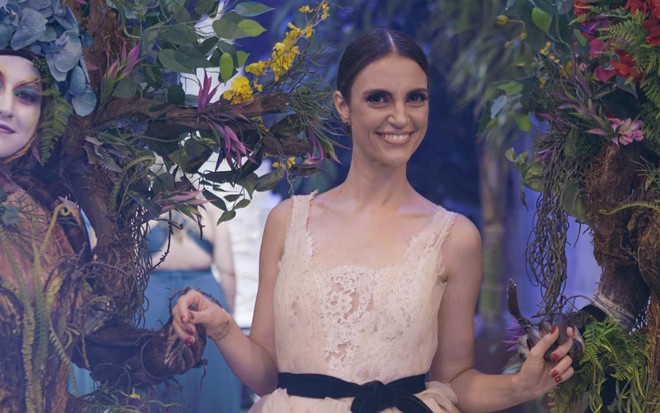Chris Flores entre pessoas fantasiadas de seres das águas, que fazem parte da decoração de um casamento - Divulgação/SBT