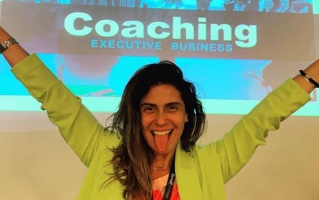 A atriz Giovanna Antonelli posa na frente de uma apresentação de power point escrito 'Coaching'