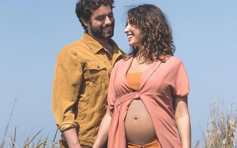 Os atores Guilherme Winter e Giselle Itié posando em um cenário de campo para ensaio da gravidez