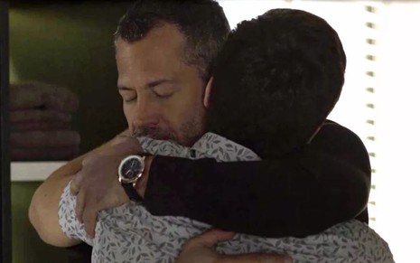 Os atores Malvino Salvador e Guilherme Leicam se abraçam em cena de A Dona do Pedaço, novela das nove da Globo
