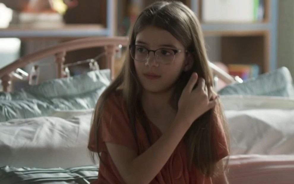 A atriz mirim Valentina Vieira usando óculos, em cena da novela Bom Sucesso, da Globo