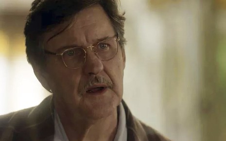 O ator Antonio Calloni caracterizado como o Júlio em cena de Éramos Seis, de óculos e pijamas, com uma expressão de surpresa
