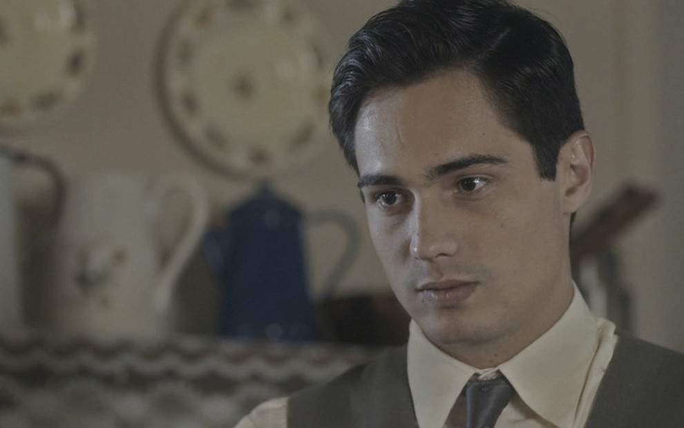 O ator Danilo Mesquita caracterizado como o personagem Carlos em cena de Éramos Seis de terno e gravata