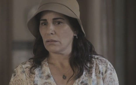 A atriz Gloria Pires caracterizada como Lola em cena de Éramos Seis: com expressão preocupada, ela usa um chapéu
