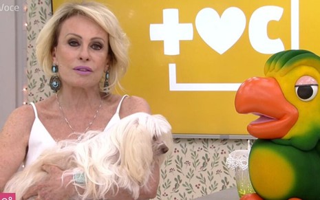 A apresentadora Ana Maria Braga com os olhos marejados e segurando uma de suas cadelas no colo durante o programa Mais Você, da Globo