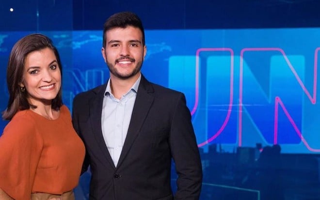 Os jornalistas Larissa Pereira, da Paraíba, e Matheus Ribeiro, de Goiás, posam no cenário do Jornal Nacional