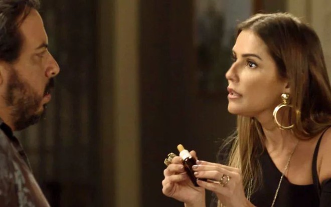 Karola (Deborah Secco) entrega sonífero para Clóvis (Luis Lobianco) em cena de Segundo Sol - Reprodução/TV Globo